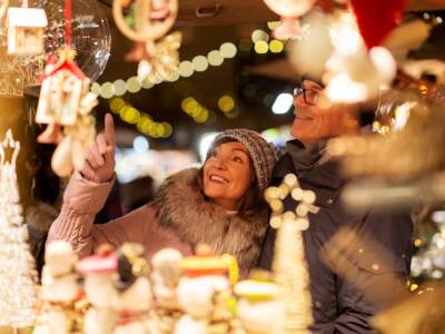 coppia guarda vetrina negozio addobbata natale