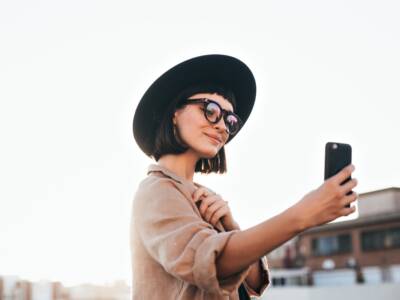 Ragazza con cappello selfie smartphone occhiali da sole