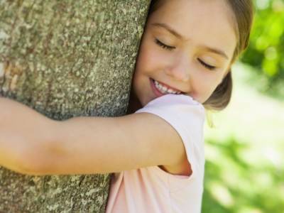 Bambina che abbraccia un albero