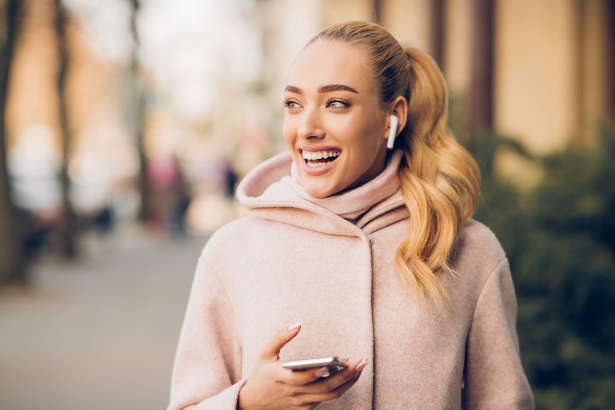 ragazza sorriso air pods giacca