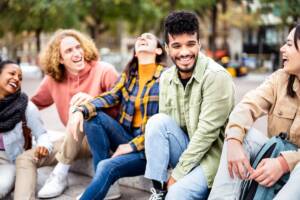 ragazzi amici millennials seduti scalinate piazza cittadina