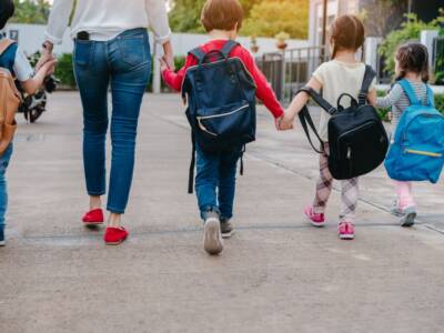 mamma accompagna bambini scuola zaini