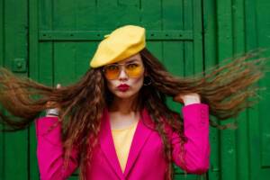 Ragazza con cappello giallo e giacca fucsia fluo