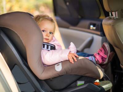 Bambina seduta sul seggiolino in auto