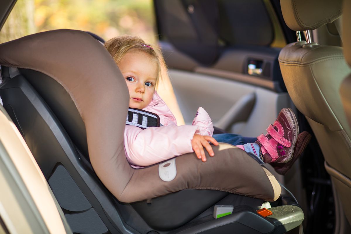 Bambina seduta sul seggiolino in auto