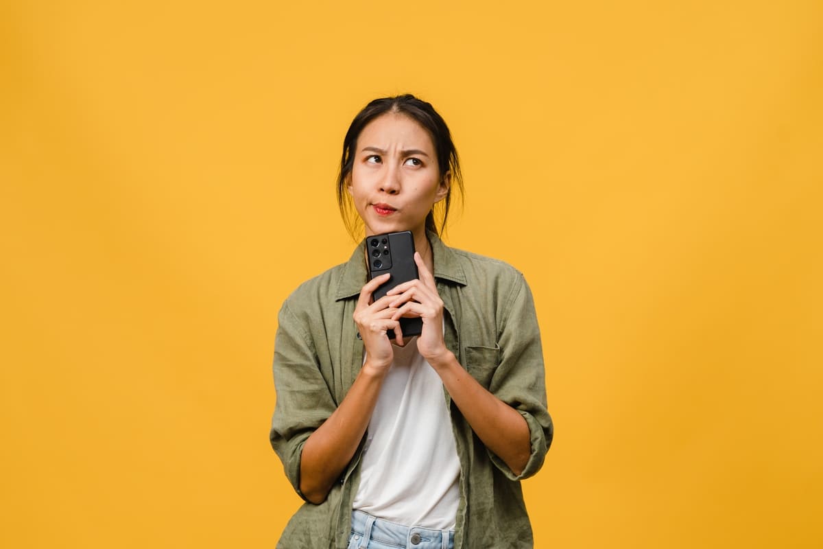 ragazza perplessa confusa pensierosa con cellulare