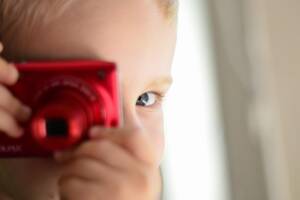 Bambino che scatta foto con macchina fotografica