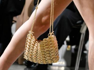 Modella di Paco Rabanne sfila con borsa dorata alla Parigi Fashion Week