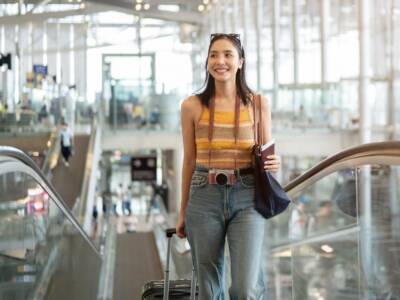 Passeggera in aeroporto con passaporto e valigia