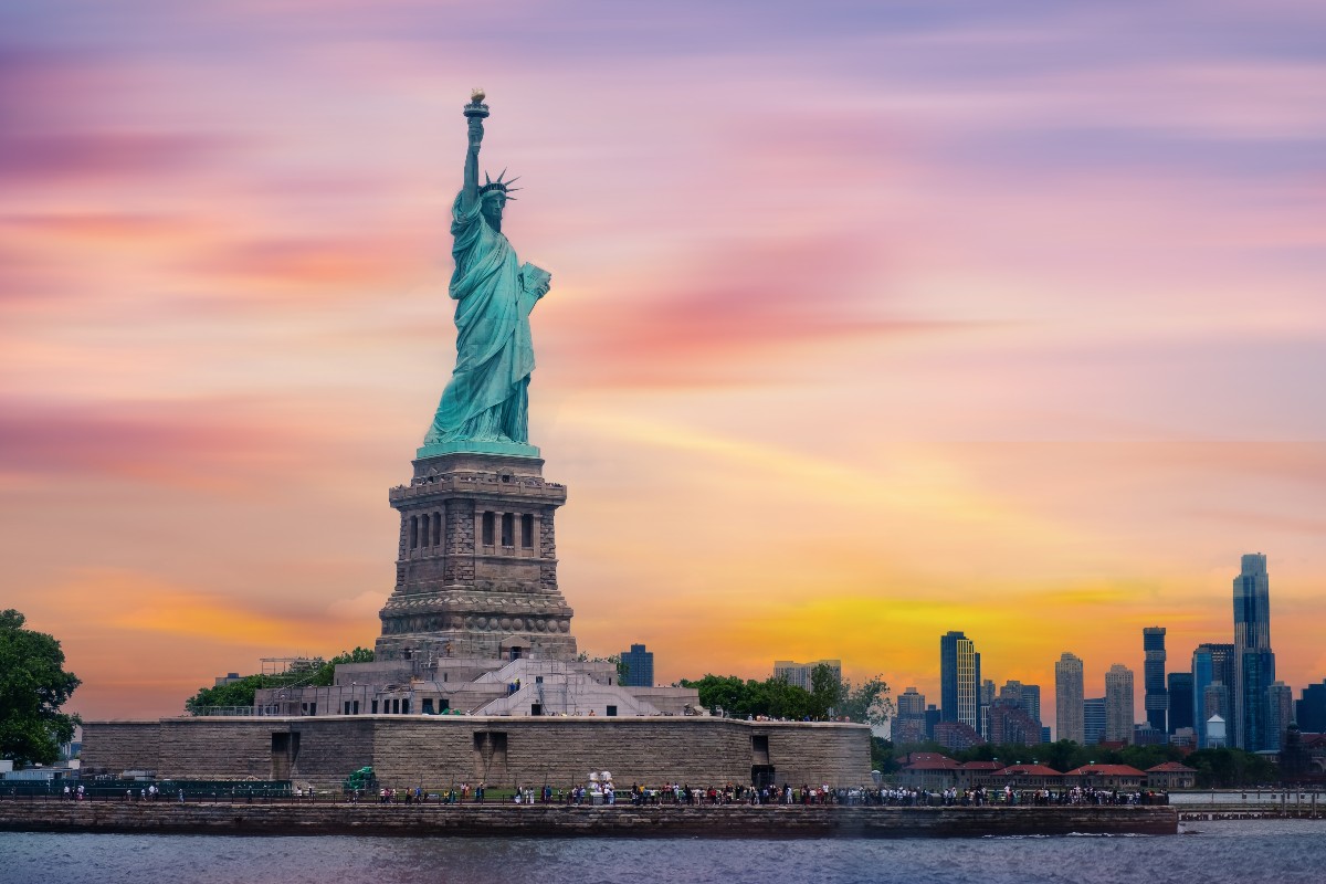 Panoramica di New York al tramonto con la statua della libertà