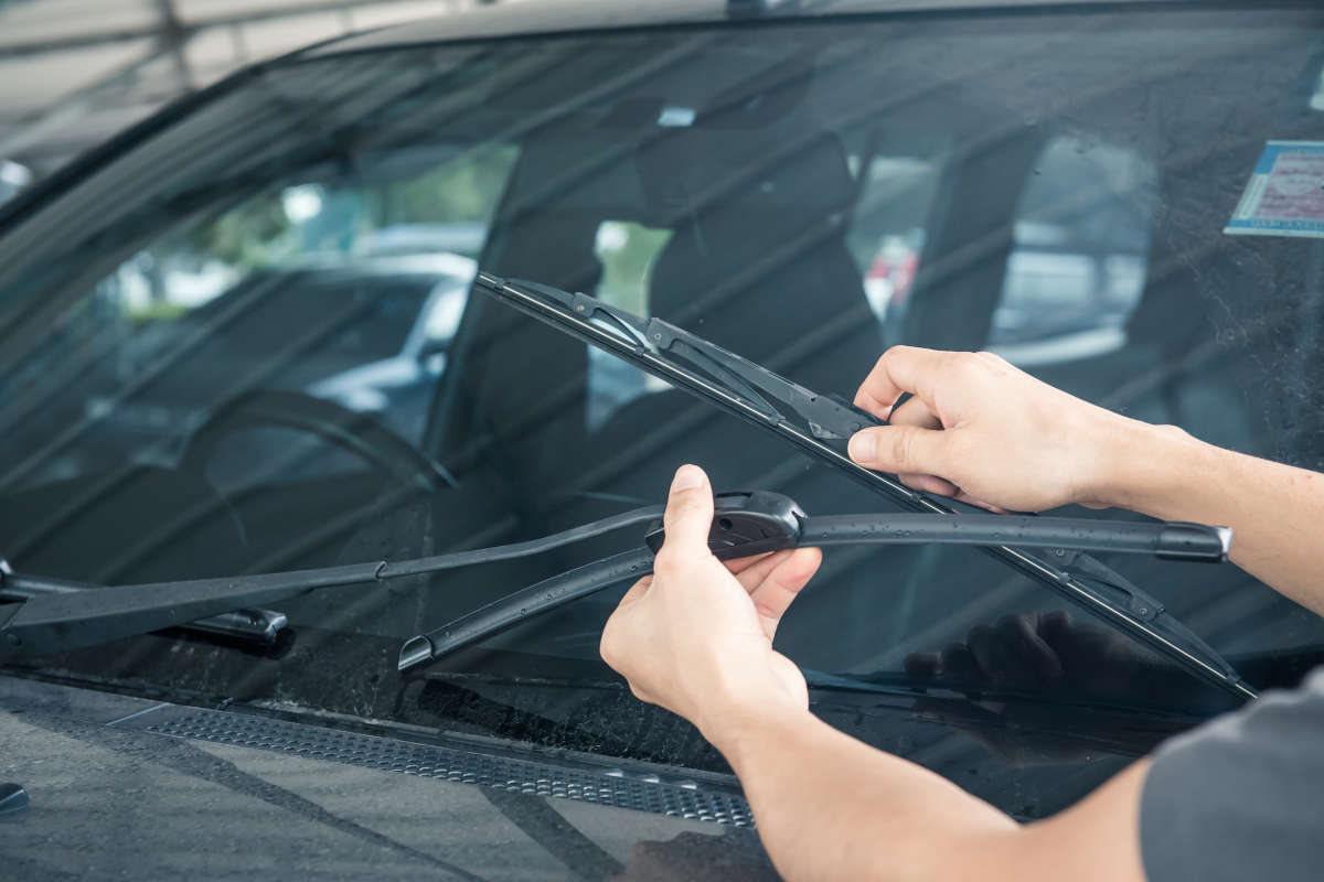 uomo che alza i tergicristalli dell'auto