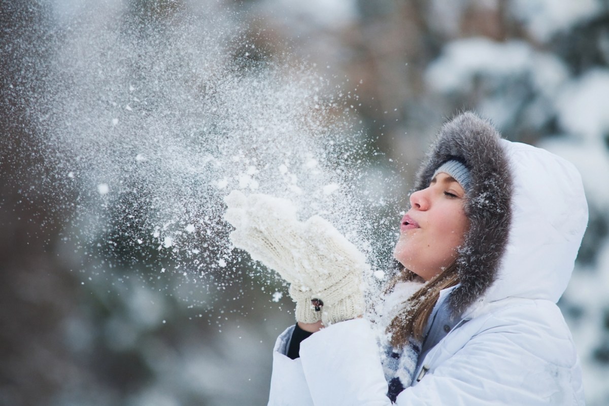 Donna soffia neve inverno