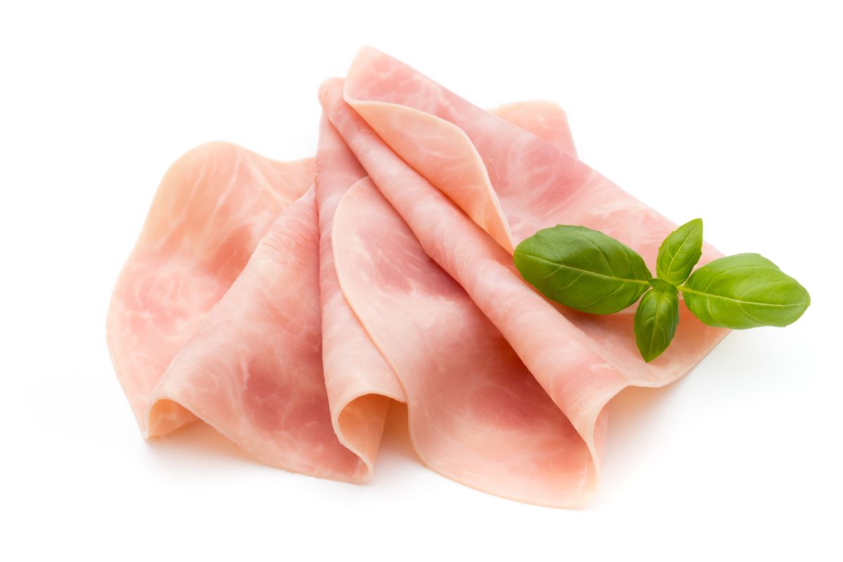 Sottili fette di prosciutto cotto disposte su un piatto.