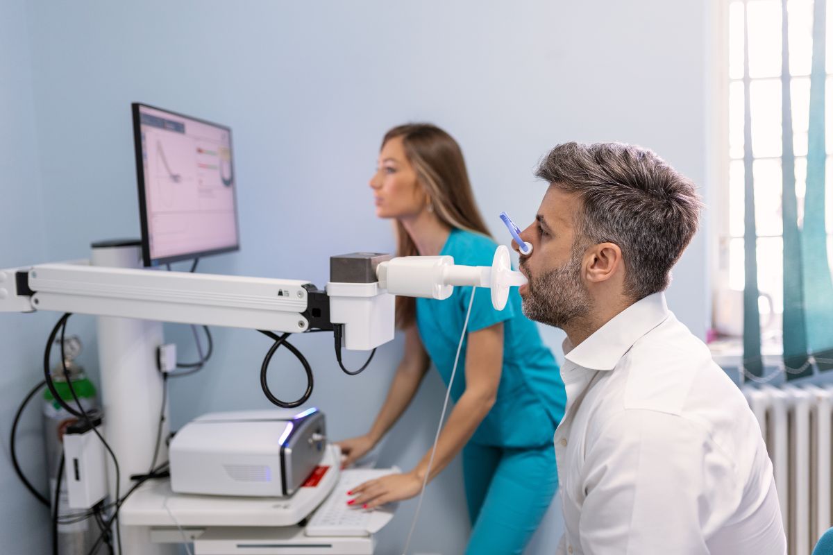 Un uomo si sottopone a una spirometria in uno studio medico con l'assistenza di una dottoressa